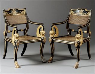 A pair of elaborate regency klismos chairs with lion’s paw feet