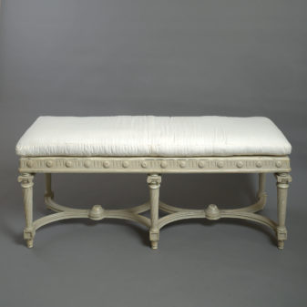 A late 19th century white painted long stool in the louis xvi manner