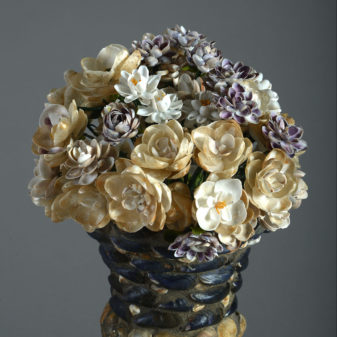 A large pair of shell encrusted urns on plinths