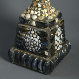 A large pair of shell encrusted urns on plinths