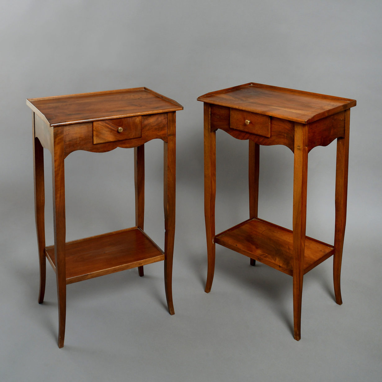 A pair of walnut bedside tables in the louis xv manner