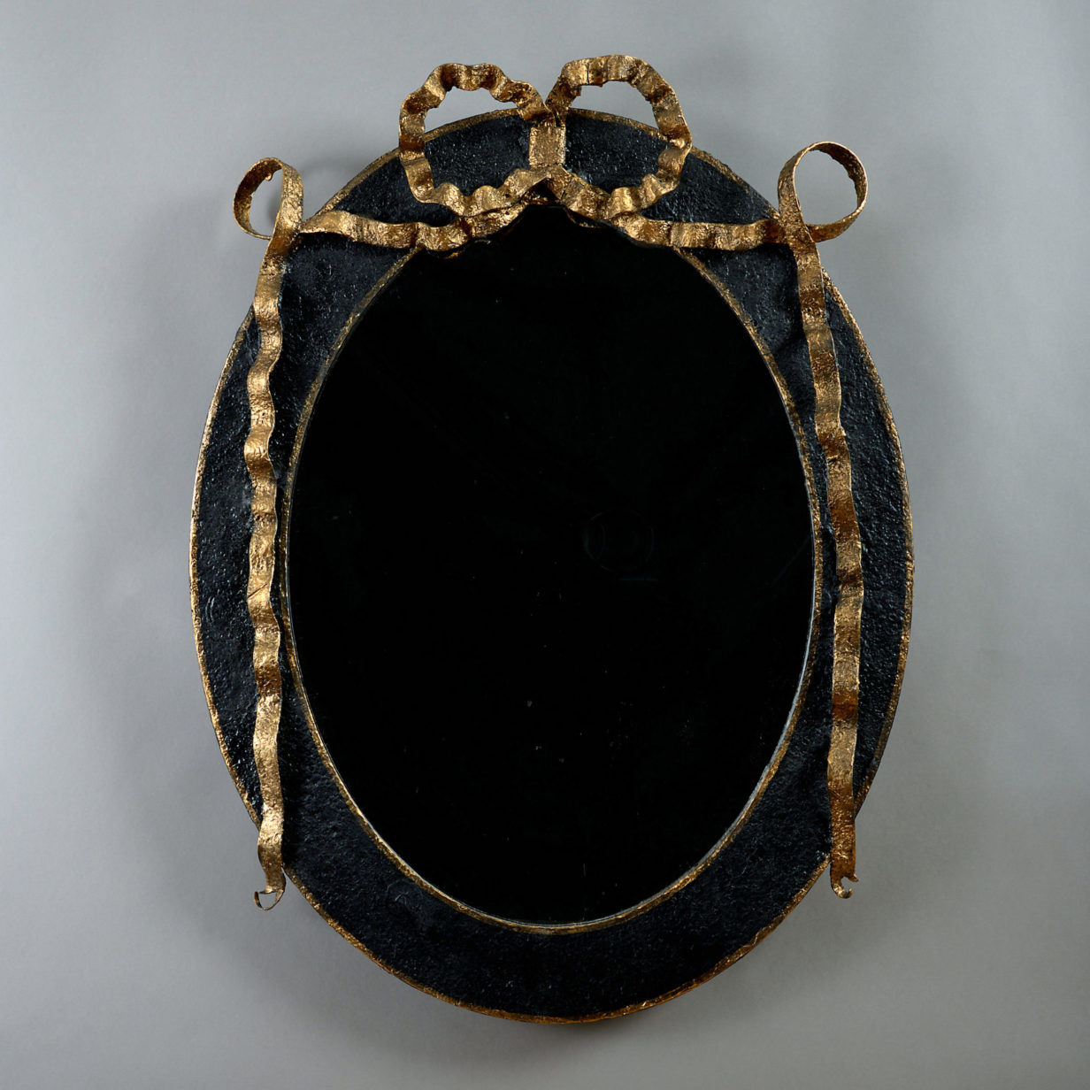 A black & gilded tôle oval mirror
