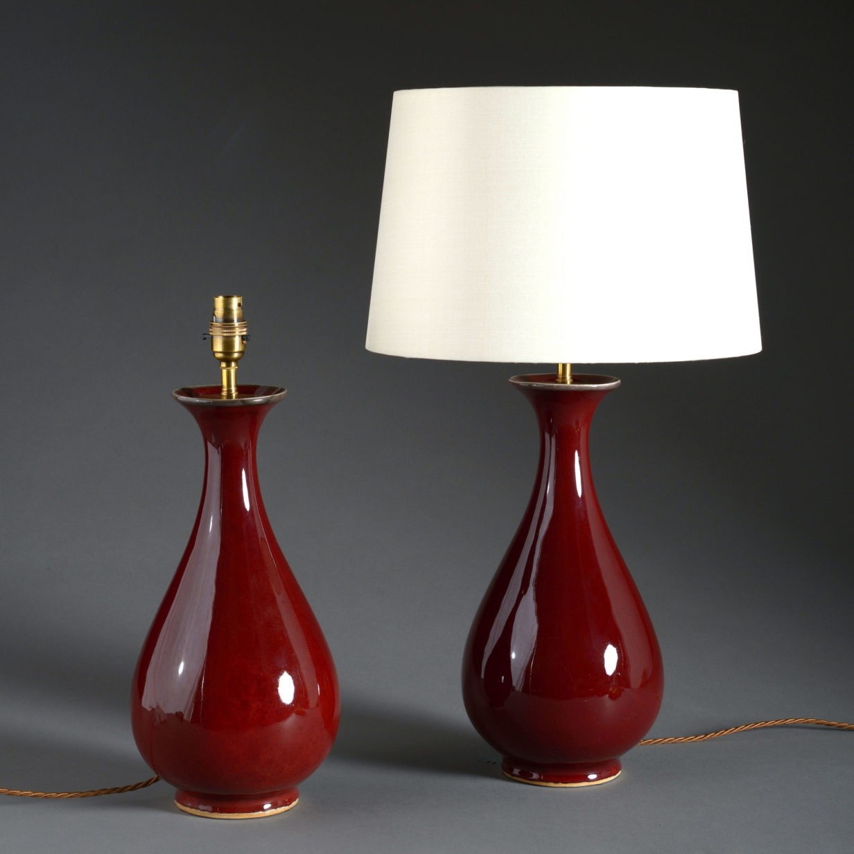 A pair of sang de boeuf porcelain vase lamps