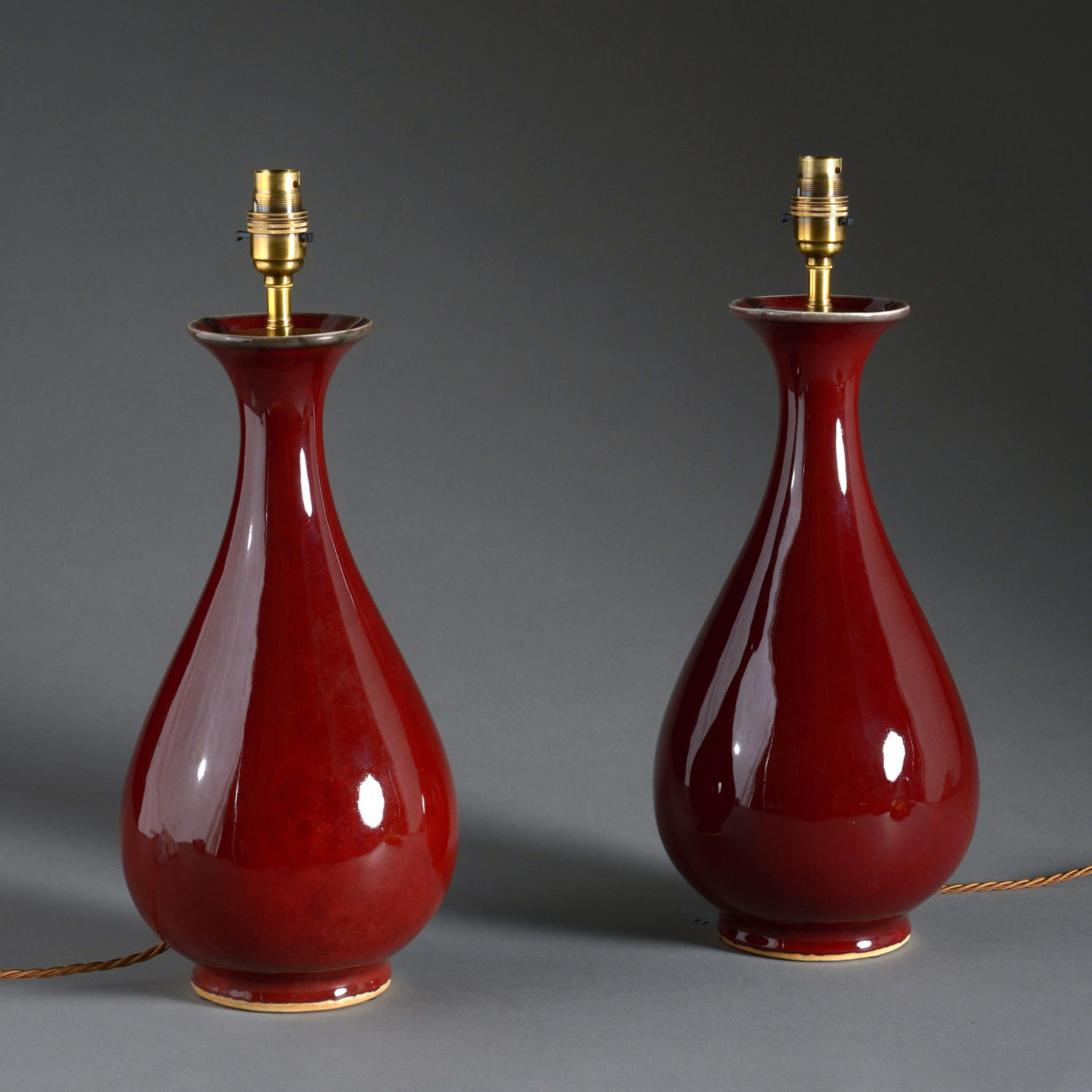 A pair of sang de boeuf porcelain vase lamps