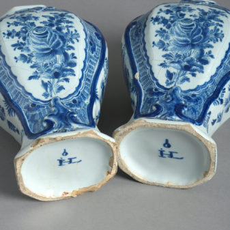 A pair of signed 18th century delft lidded vases