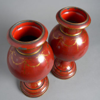A pair of red toleware late 19th century covered urns