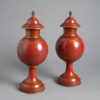 A pair of red toleware late 19th century covered urns