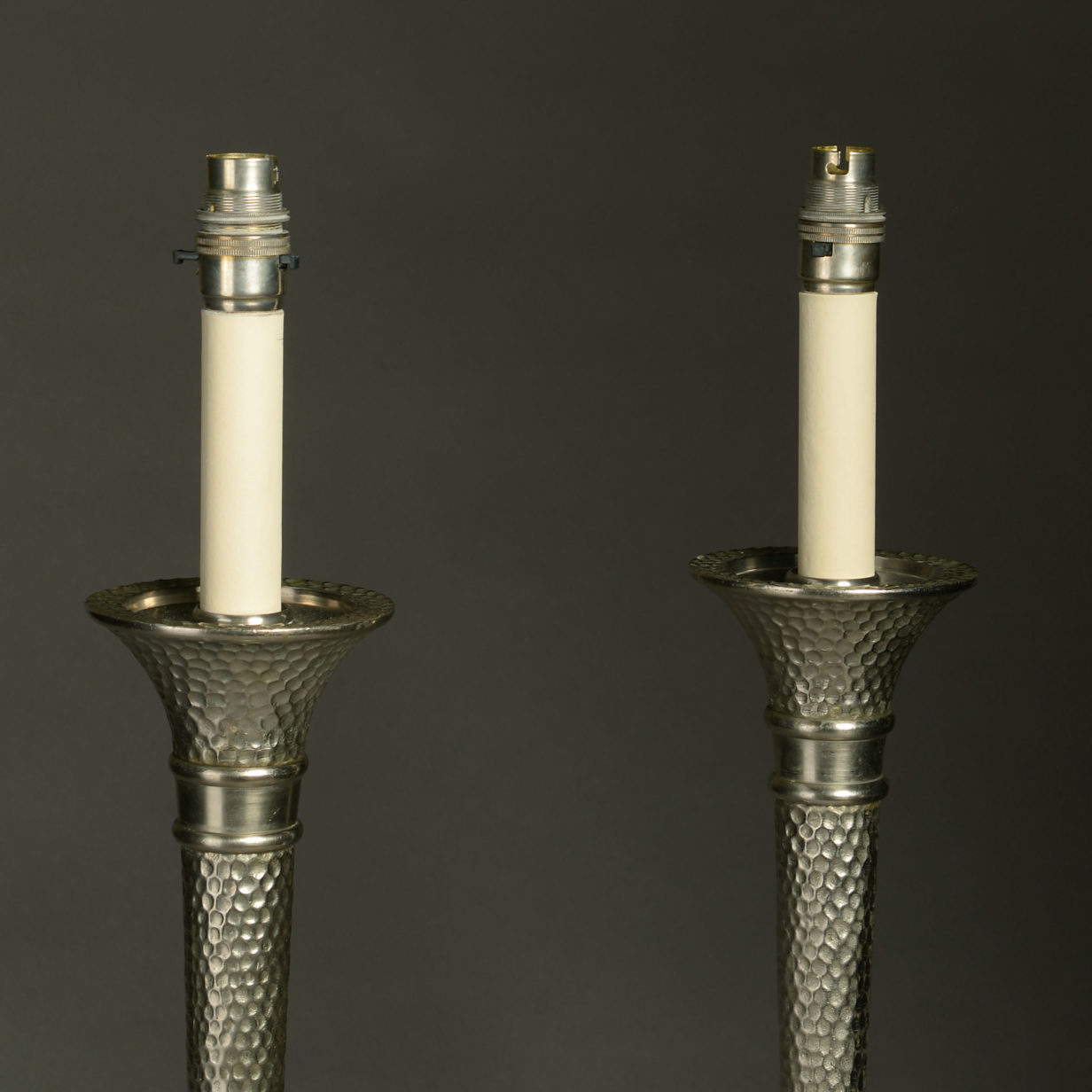 A pair of mid-century hammered steel torch lamps