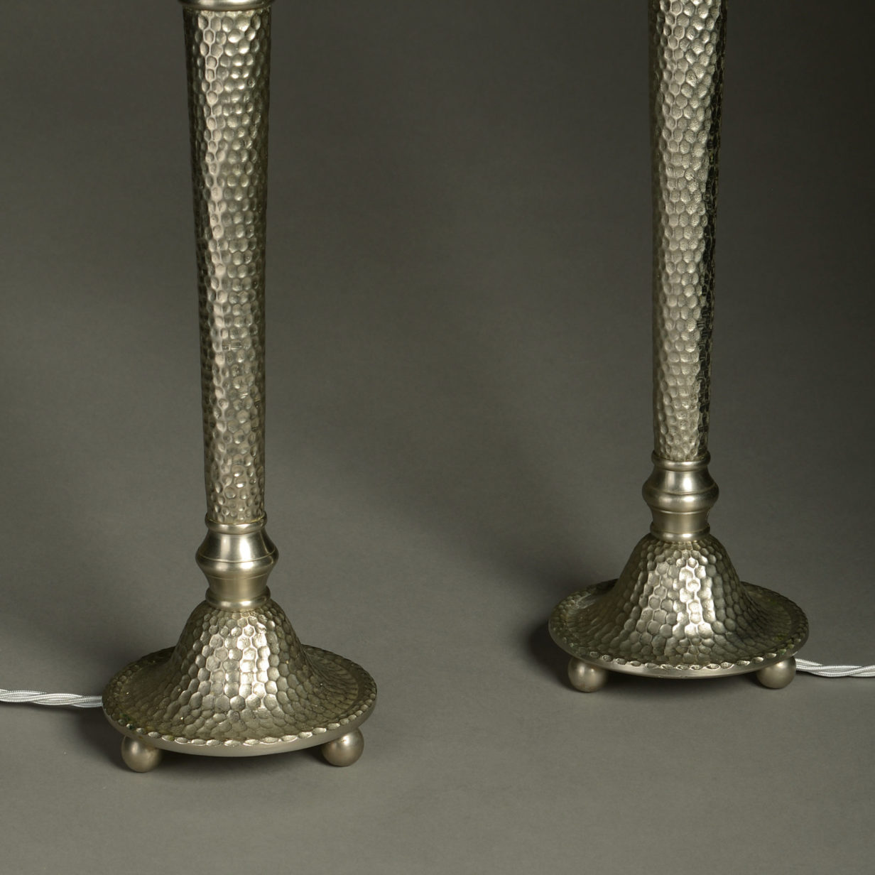 A pair of mid-century hammered steel torch lamps