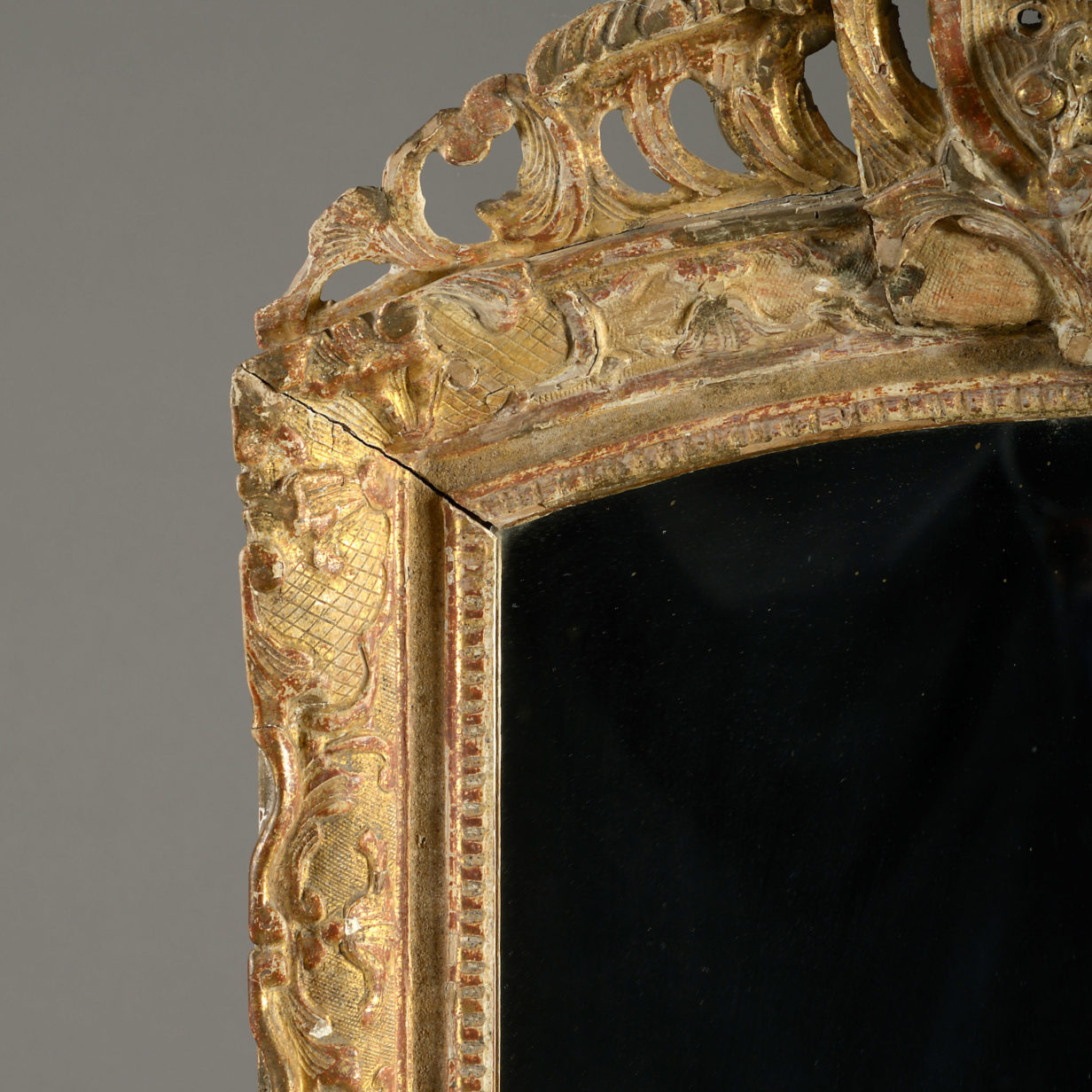 An early 18th century louis xv period giltwood mirror