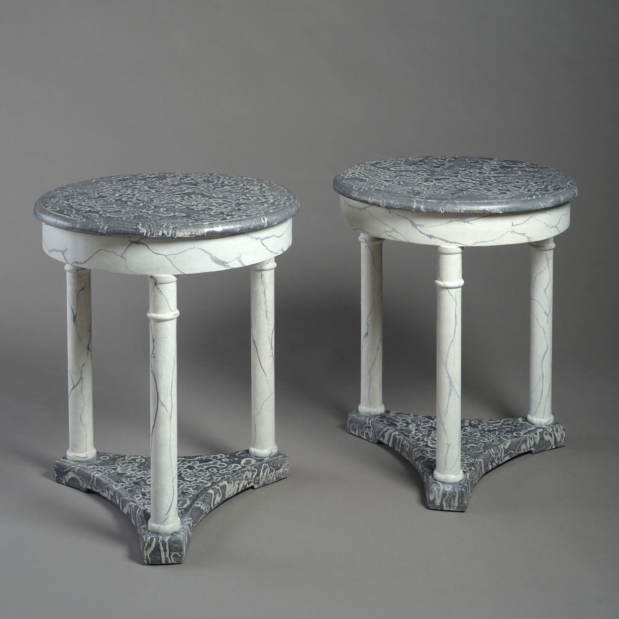 A pair of faux marble circular end tables
