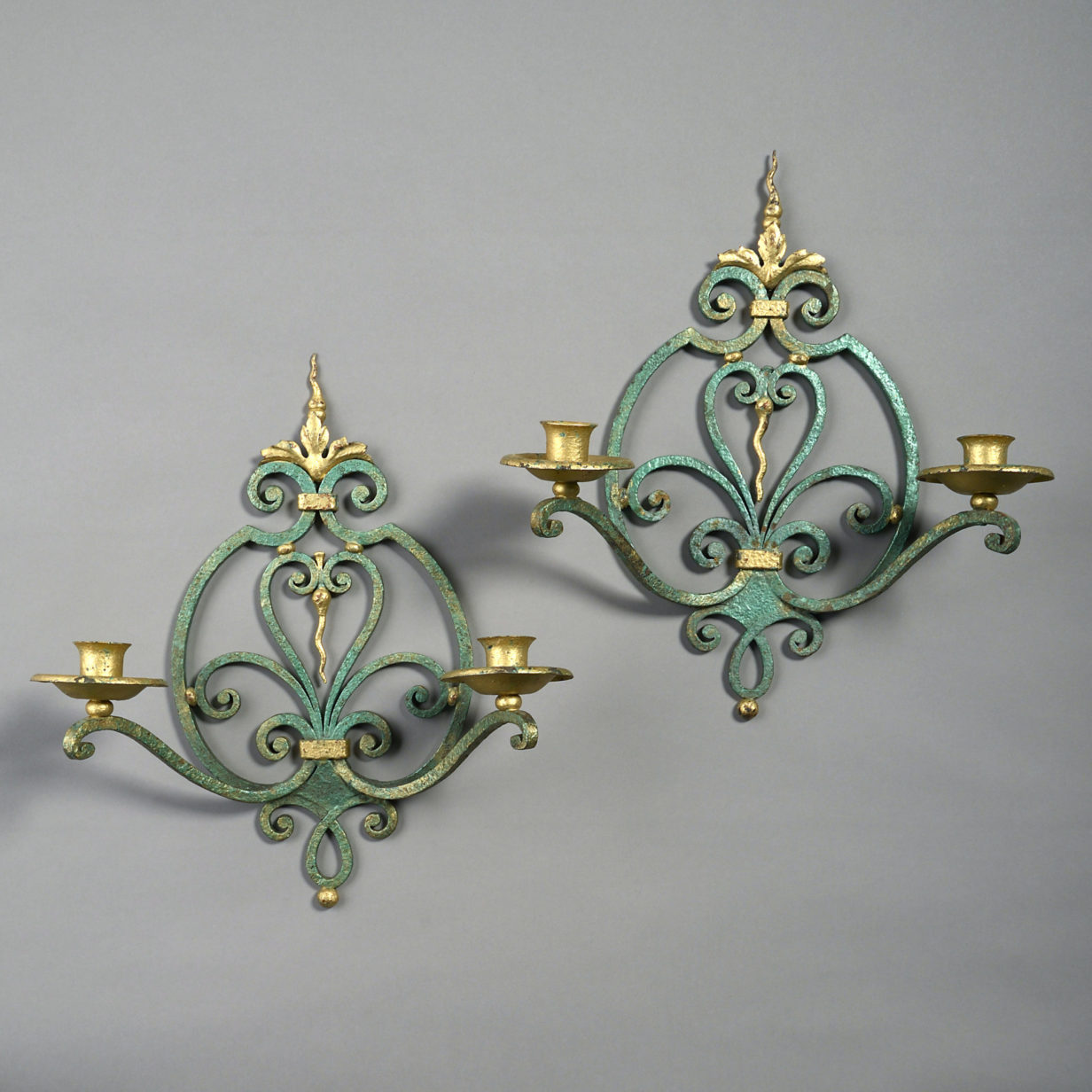 A pair of mid-century patinated and gilt iron wall lights after gilbert poillerat