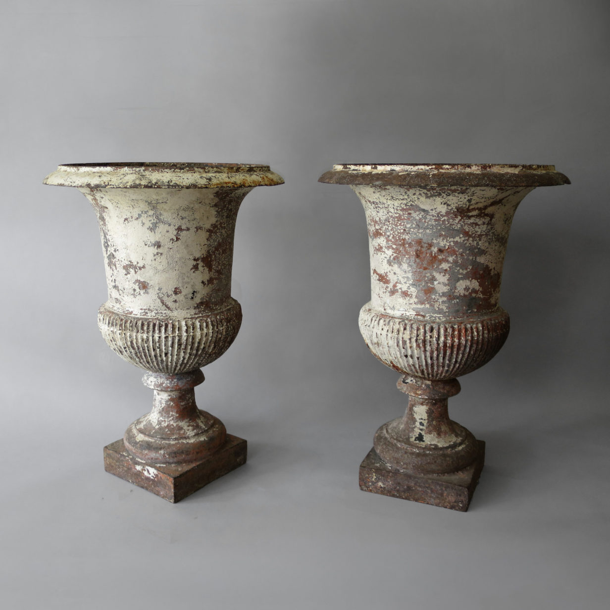 A pair of painted iron urns