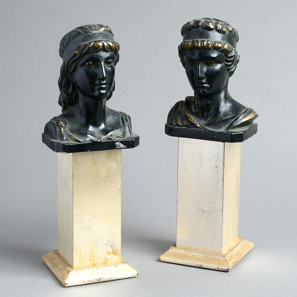 A pair of 19th century bronzed composition classical heads on silvered plinths