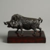 A bronzed metal boar set upon a mahogany plinth