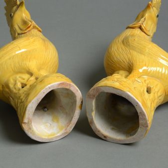 A 19th century pair of yellow glazed cockerels