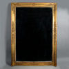 An early 19th century empire period large giltwood overmantel mirror