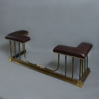 An early 20th century brass & leather club fender