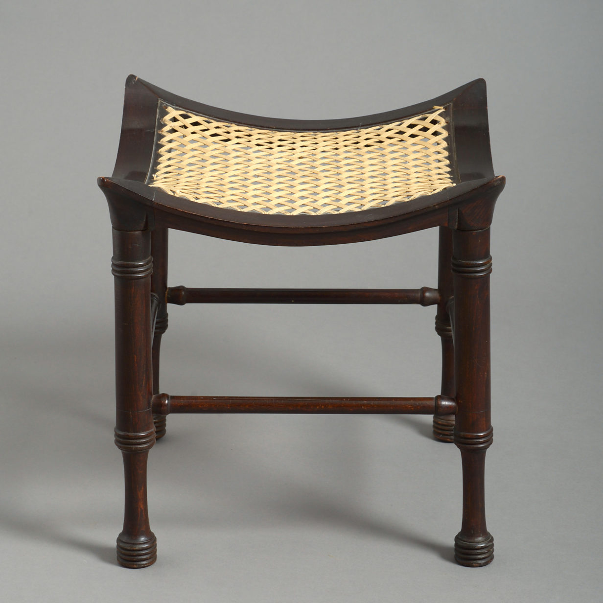 An early 20th century ebonised thebes stool