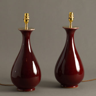 A pair of sang de boeuf glazed porcelain vase lamps