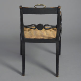 An early 19th century regency period ebonised armchair