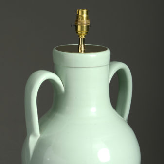 An early 20th century green glazed ceramic vase lamp base