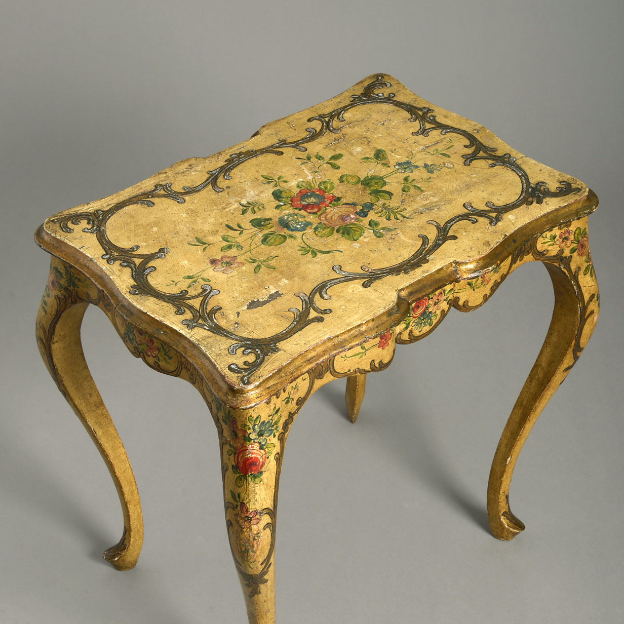 An ochre and polychrome painted rococo end table
