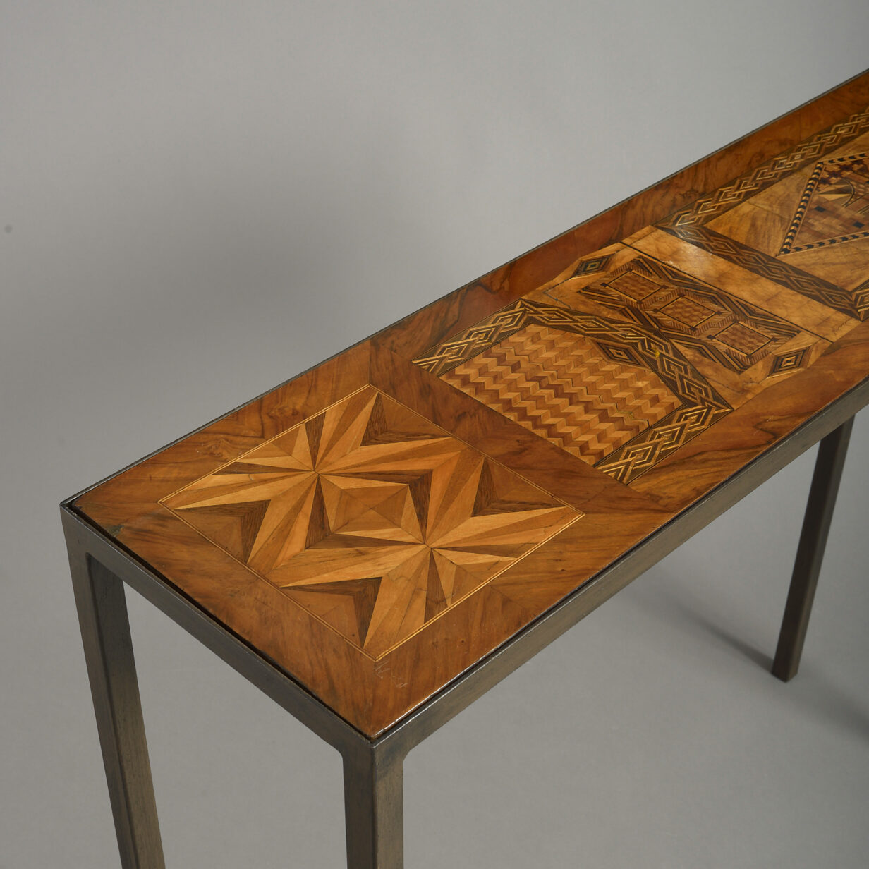 Pair of parquetry and iron console tables