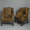 Pair of green leather wing armchairs