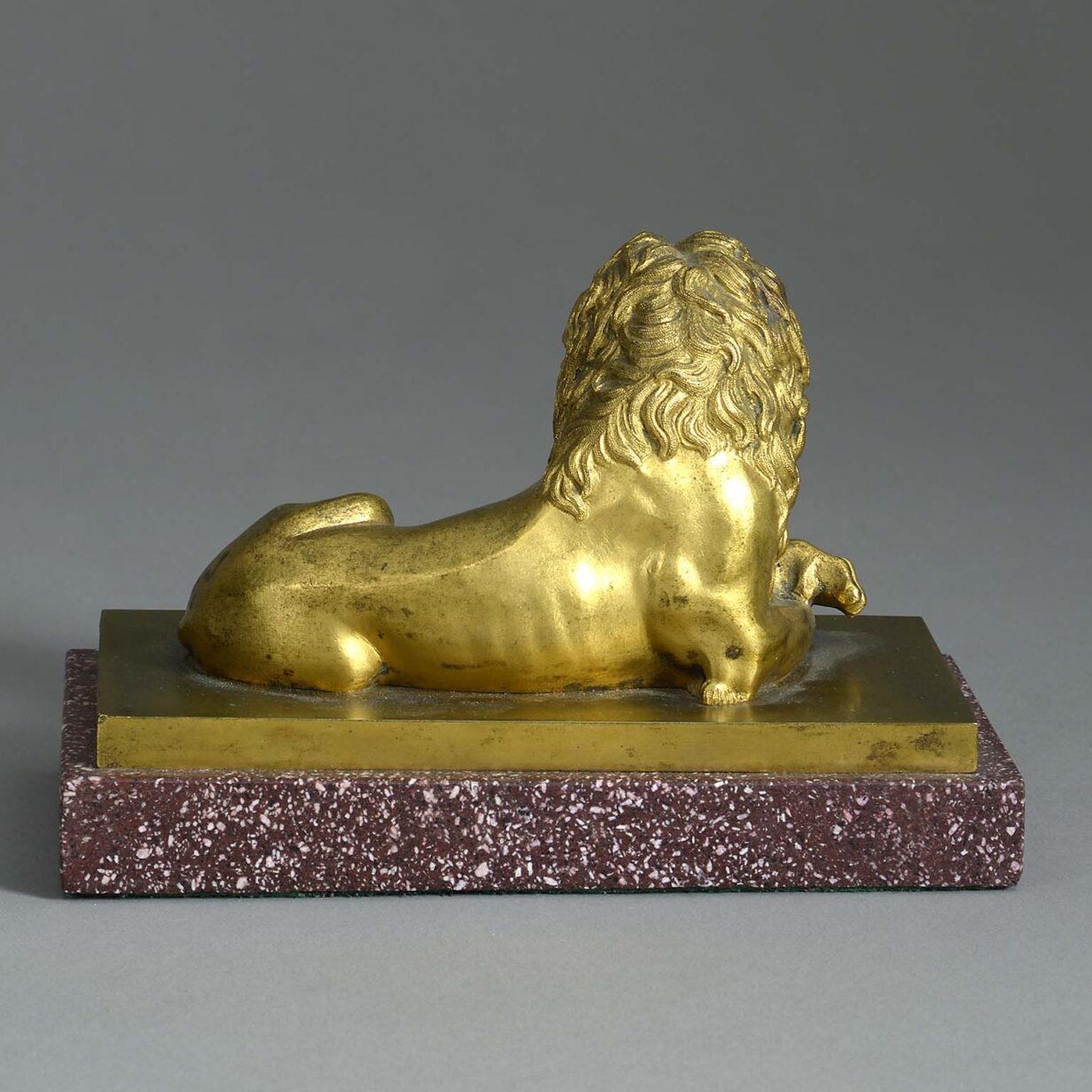 Early 19th century ormolu lion on porphyry plinth