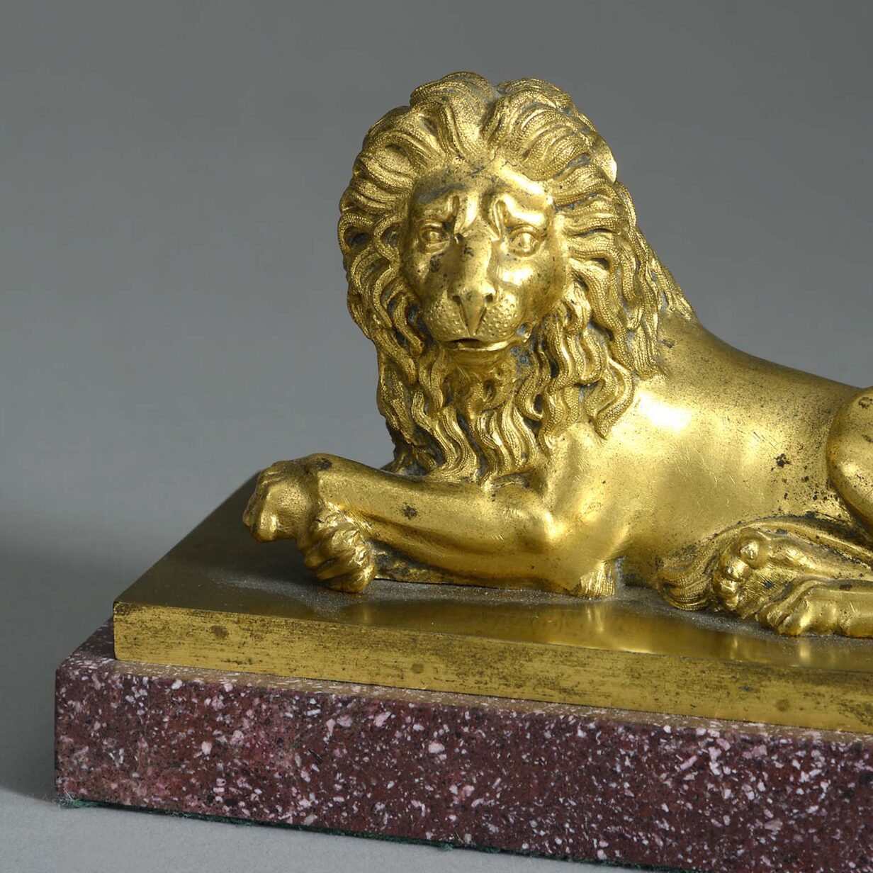 Early 19th century ormolu lion on porphyry plinth
